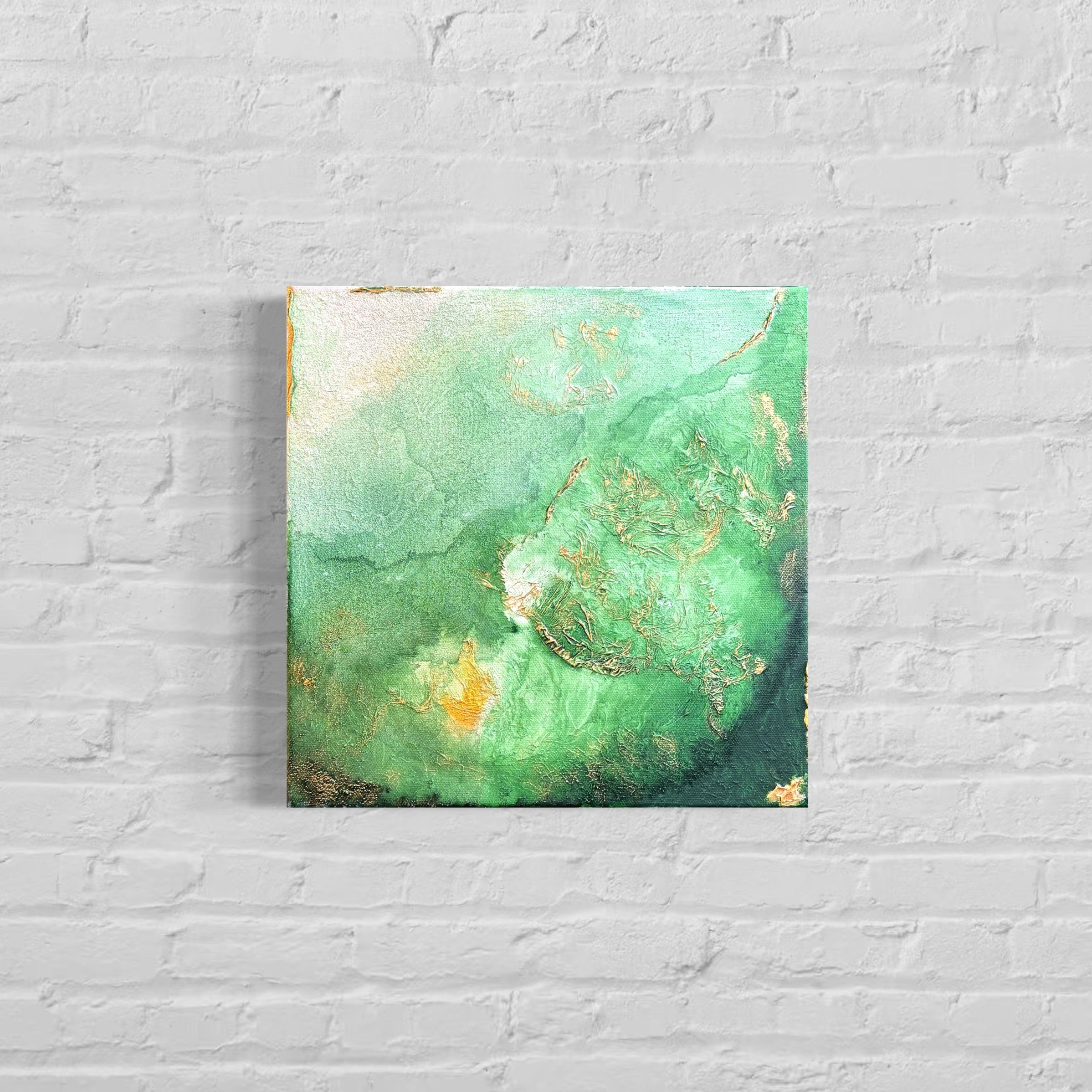 Abstract green and gold painting on a white brick wall