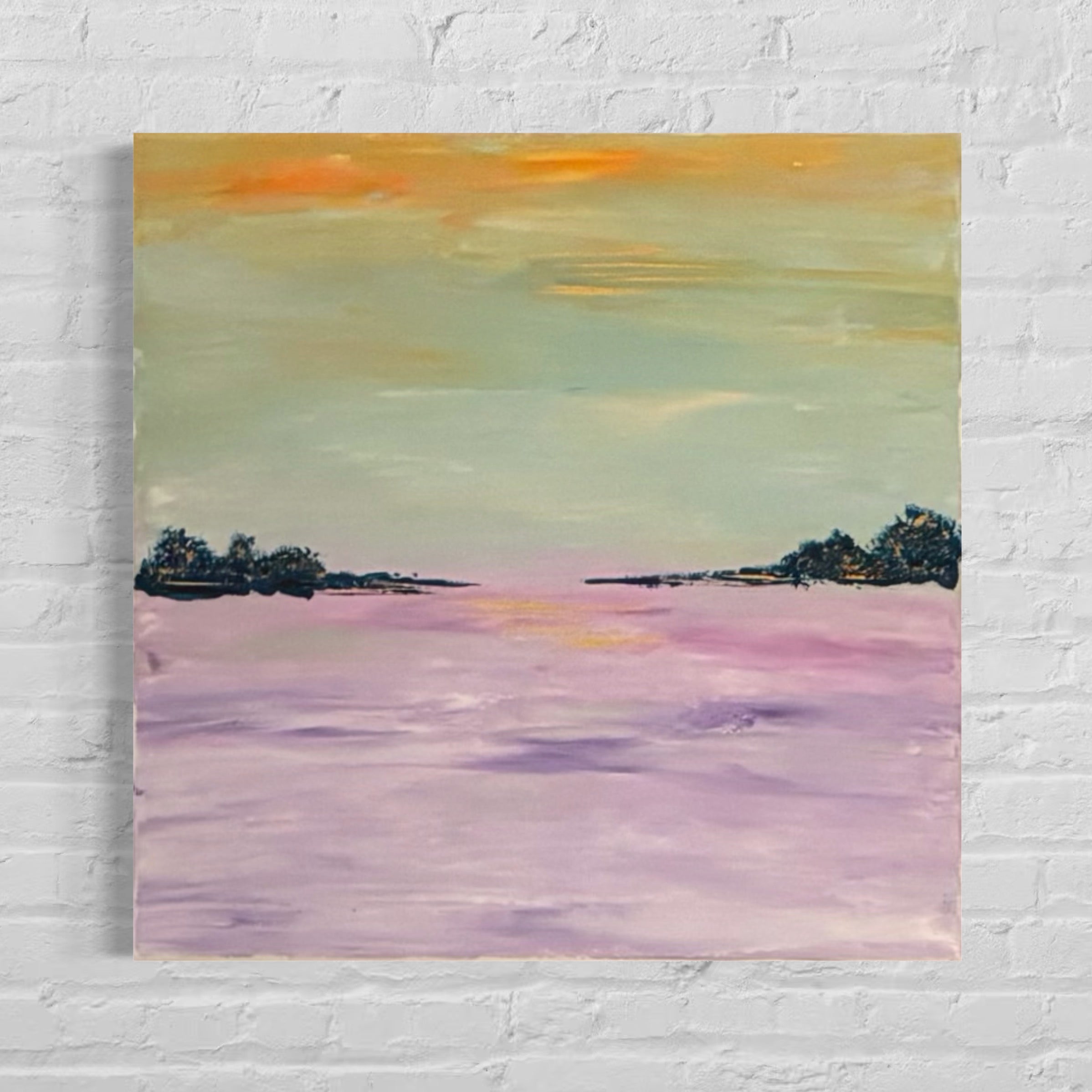 Painting of a sunset over water with trees on a white brick wall.