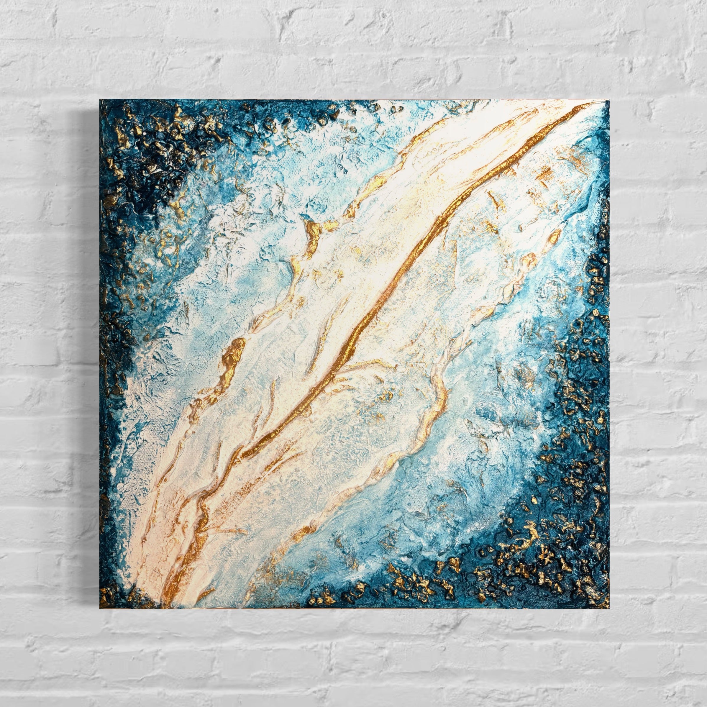 Blue white gold abstract art pieces on a textured wall.