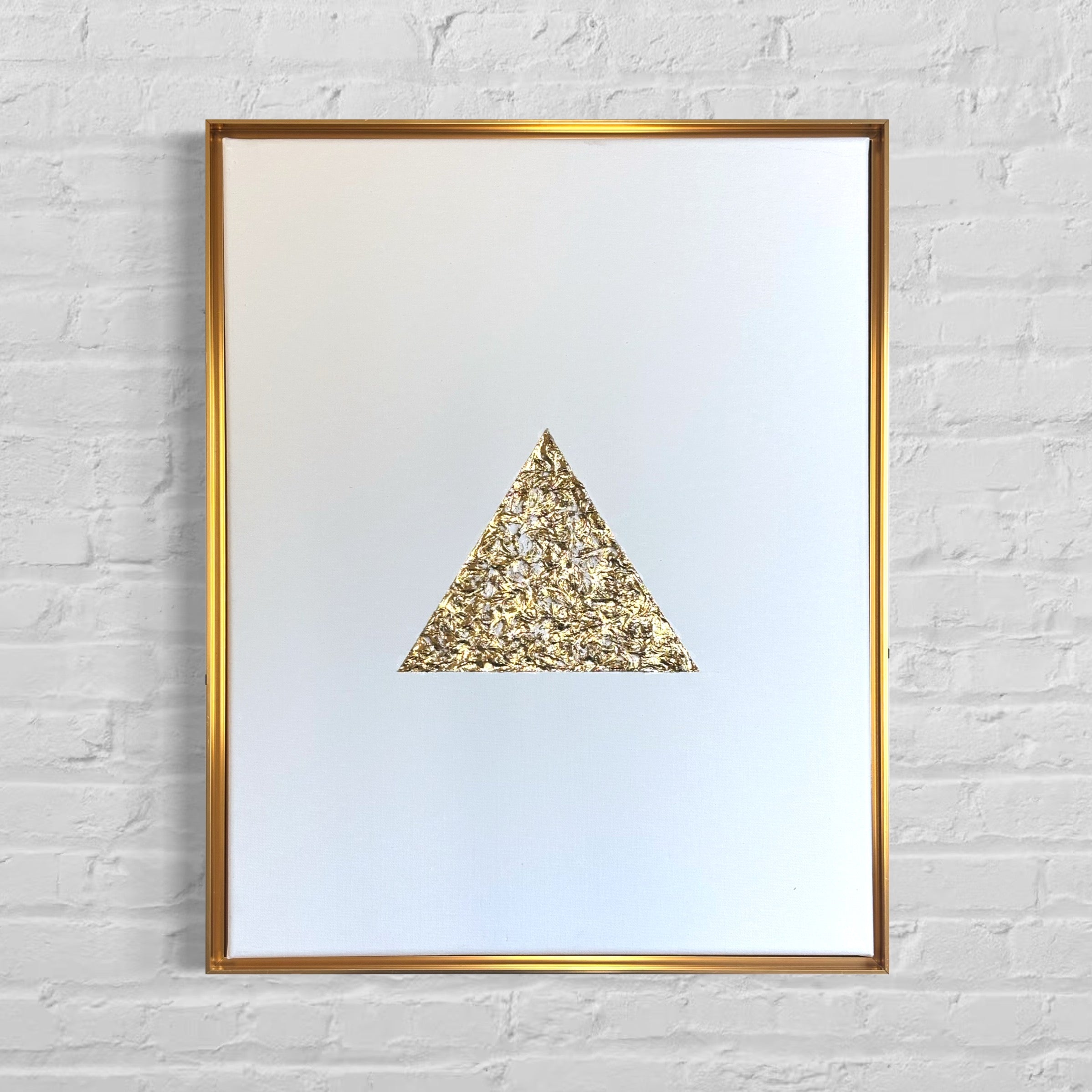 Framed artwork with a textured gold triangle on a white background