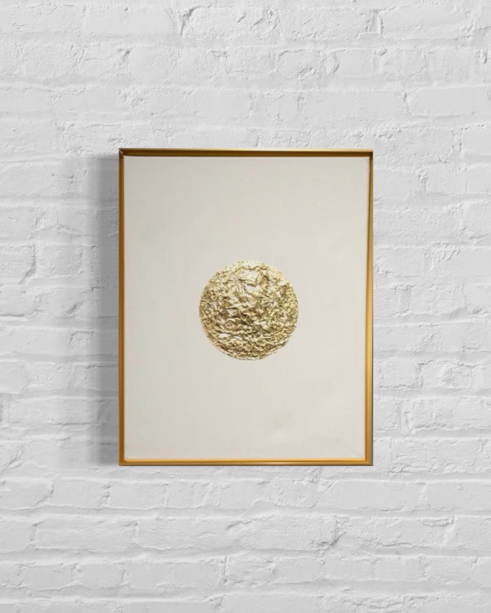 Framed artwork with a gold circular design on a white background
