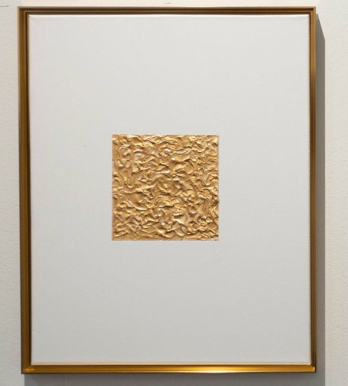 Framed artwork with a textured gold square on a white background