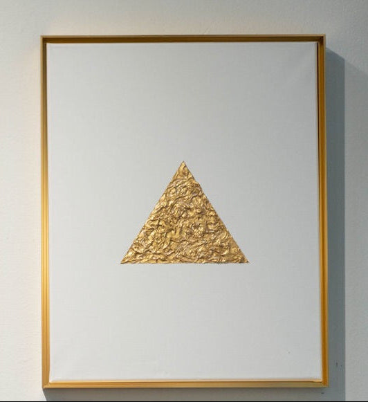 Framed artwork with a textured gold triangle on a white background