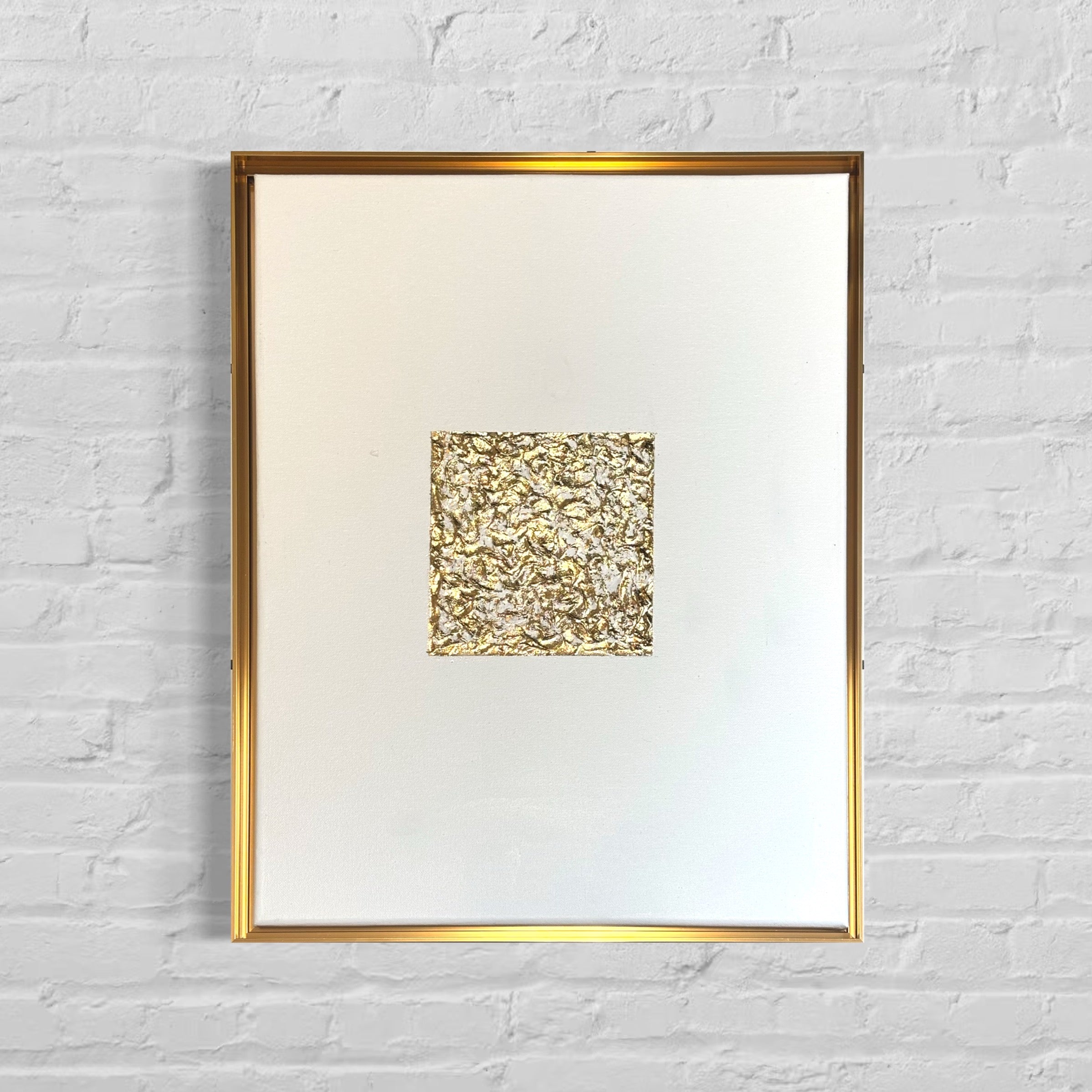 Framed artwork with a textured gold square on a white background